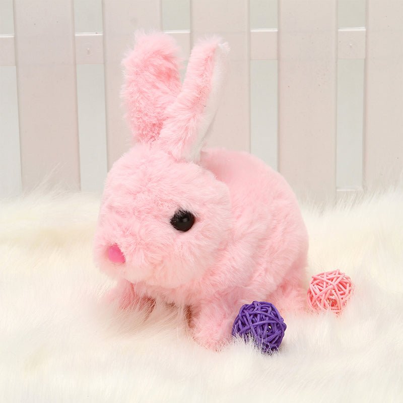 Pink plush rabbit toy with interactive features, perfect as an interactive educational toy for kids, sitting on soft fur