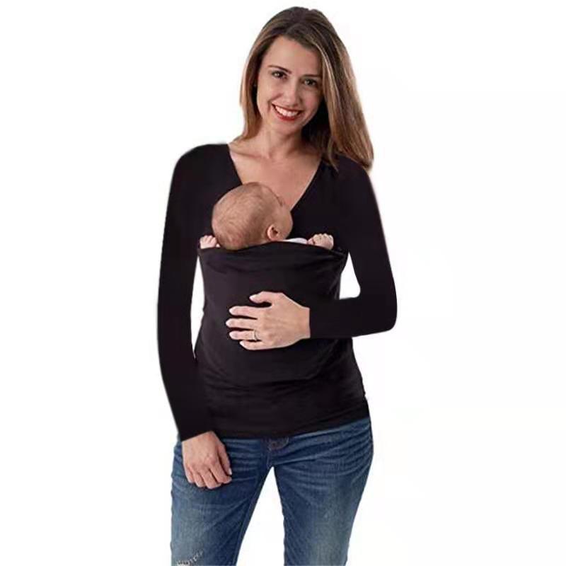 A woman wearing a kangaroo mom long sleeve shirt, comfortably holding a baby in a black long-sleeved T-shirt design