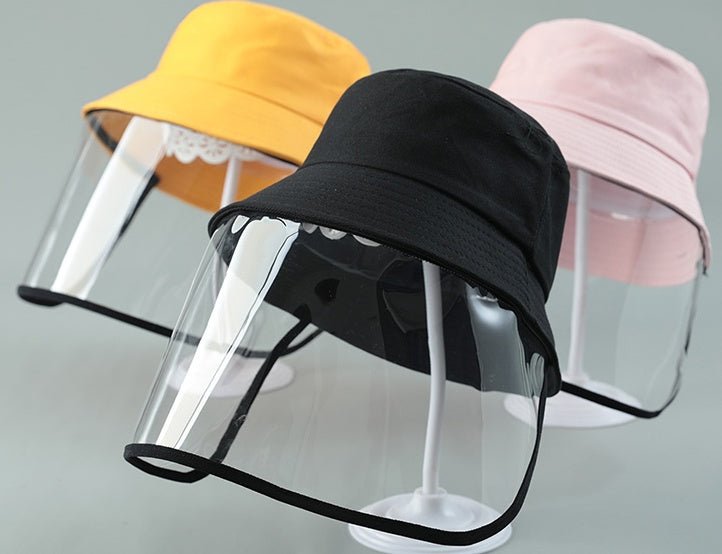 Colorful kids protective hat for spitting with a clear front shield, featuring black, pink, and yellow designs for safety