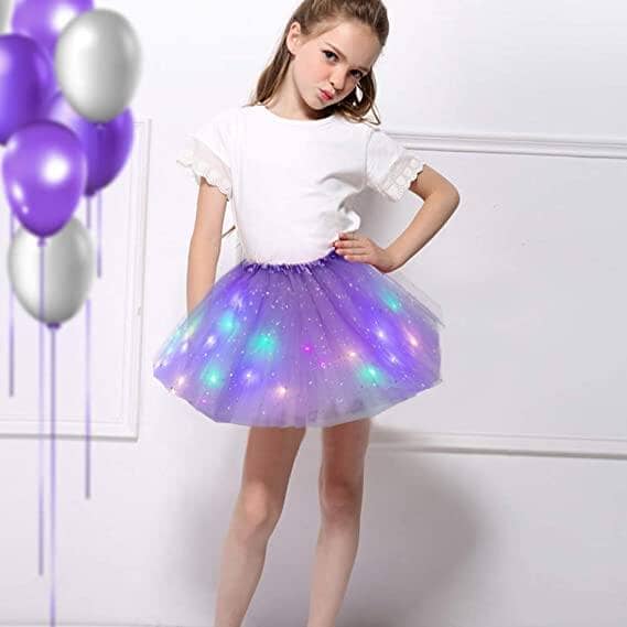 A girl wearing a magical and luminous LED tutu skirt for kids, featuring colorful lights and a fluffy purple design