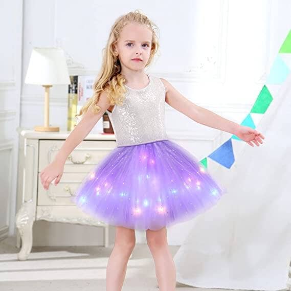 A girl twirls in a magical LED tutu skirt for kids, featuring a sparkling top and illuminated purple tulle for a whimsical look.